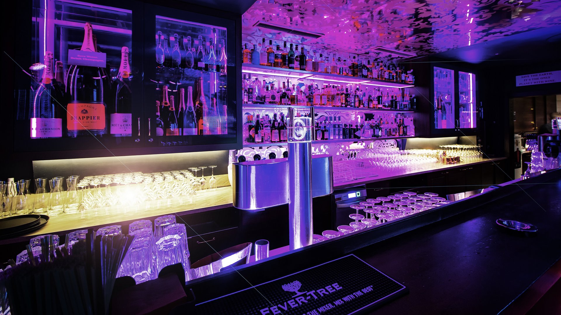 Luxuriöse Hotelbar Stilvolle Bar mit lila Beleuchtung und hochwertigen Spirituosen im Regal.